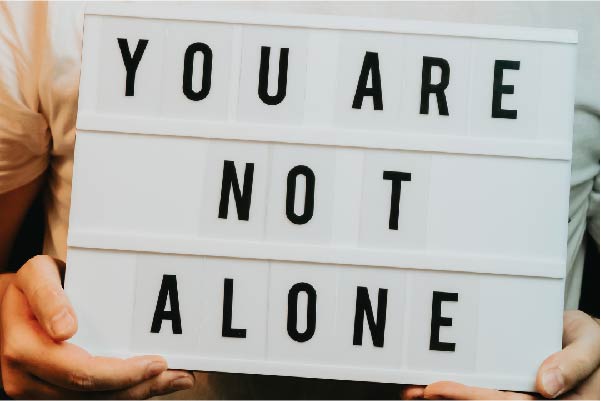 Man holding a you are not alone sign