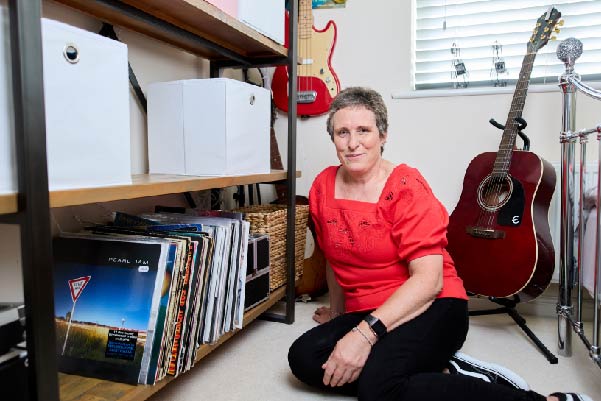 Emma sat in office on the floor next to records and a guitar