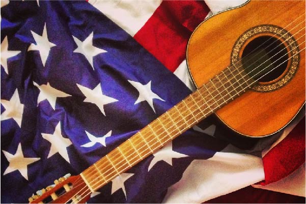 Acoustic guitar on top of the American flag