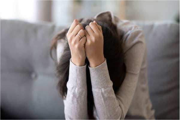 Depressed woman with head in her hands