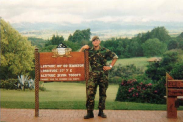 Veteran Colin standing in a green mountainous area wearing camouflaged clothes