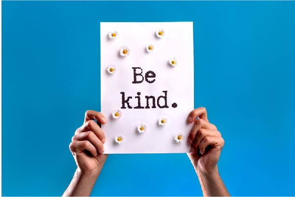 Hands holding a Be Kind sign