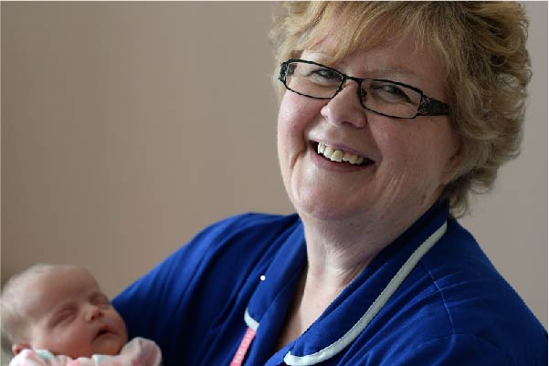 Colchester Hospital nurse holding a new born baby