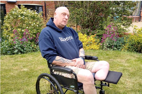 Limbless veteran sat in a wheelchair in the garden